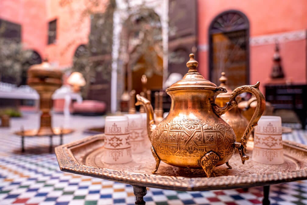 close-up-decorative-ancient-metal-teapot-with-cups-table